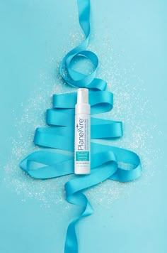 a tube of eye cream sitting on top of a blue ribbon