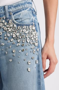 a woman wearing jeans with silver sequins on it