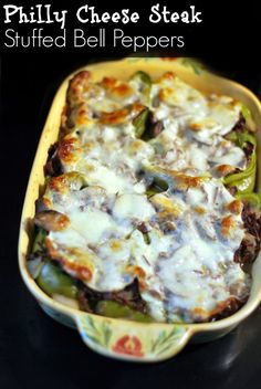 a casserole dish with cheese and peppers in it on a black table top