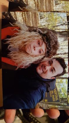 two people standing next to each other holding up a polaroid with an image on it