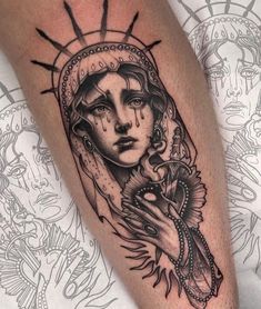 a woman's arm with tattoos on it and an image of the virgin mary