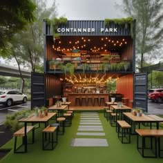 an outdoor venue with tables and benches in front of the entrance to a parking lot