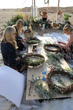 three women sitting around a table with wreaths on it