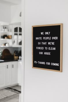 a black and white sign hanging on the side of a wall next to a kitchen