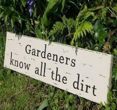 a sign that says gardener's know all the dirt is in front of some bushes