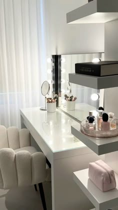 a white counter top sitting under a window next to a chair and table with makeup on it