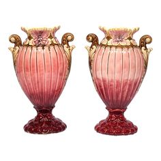 two pink and gold vases sitting next to each other on top of a white surface