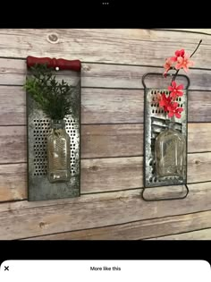 two metal wall hangings with flowers and vases on them against a wooden wall