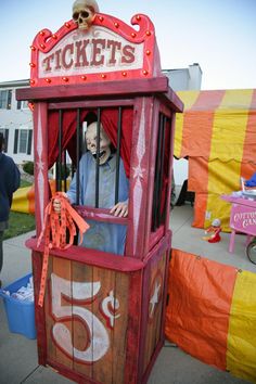 a man in a red and yellow ticket booth