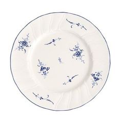 a white plate with blue flowers and vines on it, sitting in front of a white background