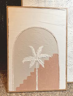 a painting of a palm tree in front of a white frame with pink and beige background