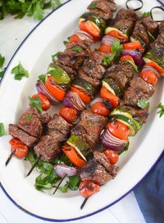 skewered meat and vegetables on a white plate