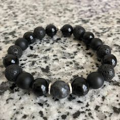 Lava Stone, Matte Black Onyx, And Onyx 10mm Bracelet w/ Silver Accents Mixed, matched, and designed with a variety of elegant beads for a graceful look. This is a beautiful piece made to be worn separately or combined with our other Embody'd Art pieces! This bracelet can also be worn as an oil diffuser. Just add one drop of your favorite oil to the AAA grade lava beads and you're set to go. This bracelet is crafted with quality elastic stretch cord. This bracelet is also designed to fit snug on Black Beaded Wristband Bracelet, Spiritual Black Beaded Wristband, Black Beaded Bracelet With 8mm Beads, Black Beaded Wristband As Gift, Black Beaded Round Stretch Bracelet, Black Beaded Stretch Bracelet, Black Beaded Bracelets With Spacer Beads As Gift, Black Crystal Bracelet With Spacer Beads For Gift, Black Round Beads Wristband As Gift