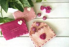 three crocheted purses sitting on top of a table next to a potted plant