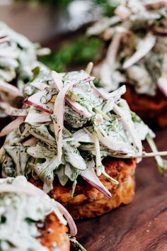 some food that is on top of a wooden table with greens and onions in it