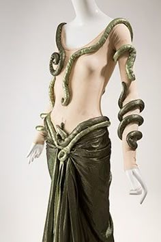 a mannequin wearing a green dress with snakes on it's back and arms