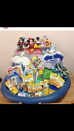 a blue inflatable bowl filled with lots of toys and other items sitting on top of a wooden table