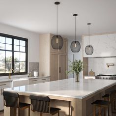 a large kitchen with marble counter tops and black chairs in front of an island that has three pendant lights hanging from the ceiling