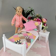 a doll standing next to a bed with flowers on it