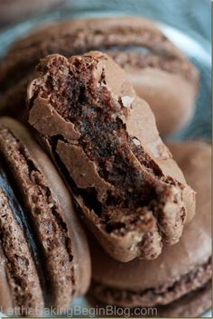 some chocolate cookies are stacked on top of each other with one cookie broken in half