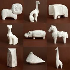 several white ceramic animals and sculptures on brown background