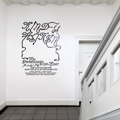 a white hallway with black and white wall decals on the walls next to a door