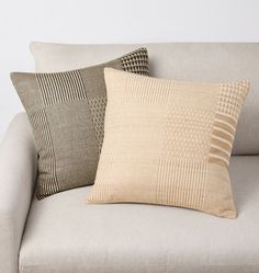 three pillows sitting on top of a couch