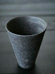 a black cup sitting on top of a wooden table