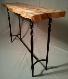 a wooden table with metal legs on a white background