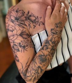 a woman with tattoos on her arm and chest holding her hands to her face while looking at the camera