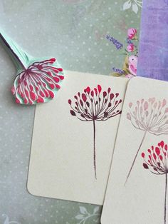 two cards with flowers on them sitting next to each other