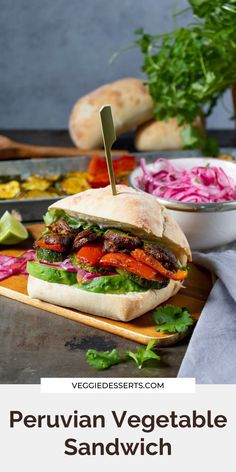 a sandwich with lettuce, carrots and other vegetables on a cutting board