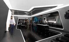 a man is standing in front of a futuristic room with sound equipment and people looking at it