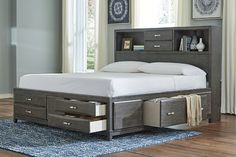 a bed with two drawers underneath it and a bookcase on the top of it