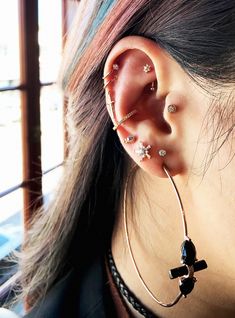 a woman with ear piercings on her ears and behind the ear are three stars