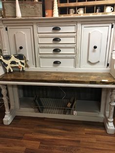 an old dresser with some drawers on it and a cow figurine sitting on top