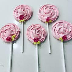 four pink lollipops with flowers on them