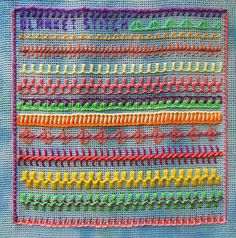 a close up of a piece of cloth with different colored stitchs on the side