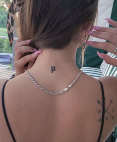 a woman with a tattoo on her neck and the letter h behind her back shoulder