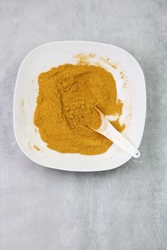 a white bowl filled with yellow colored powder