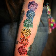 a woman's arm with seven chakras on it