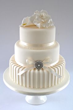 a three tiered wedding cake with white frosting and flowers on the top layer