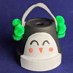 a painted black and white hat with green pom - poms