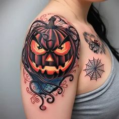 a woman's shoulder with a pumpkin and spider web tattoo design on her arm