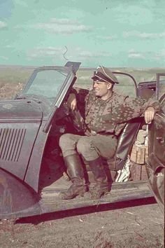 an old photo of a man sitting in the back of a pick - up truck