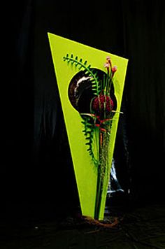 a vase with flowers in it sitting on a black surface next to a dark background