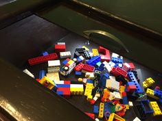 a bunch of legos that are laying on the floor in front of a drawer