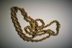 a gold chain is shown on a white surface