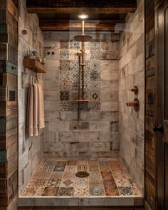 a walk in shower sitting next to a wooden floor and wall with tile on it