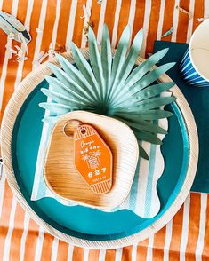 an orange and white place setting with pineapples on the plate next to it